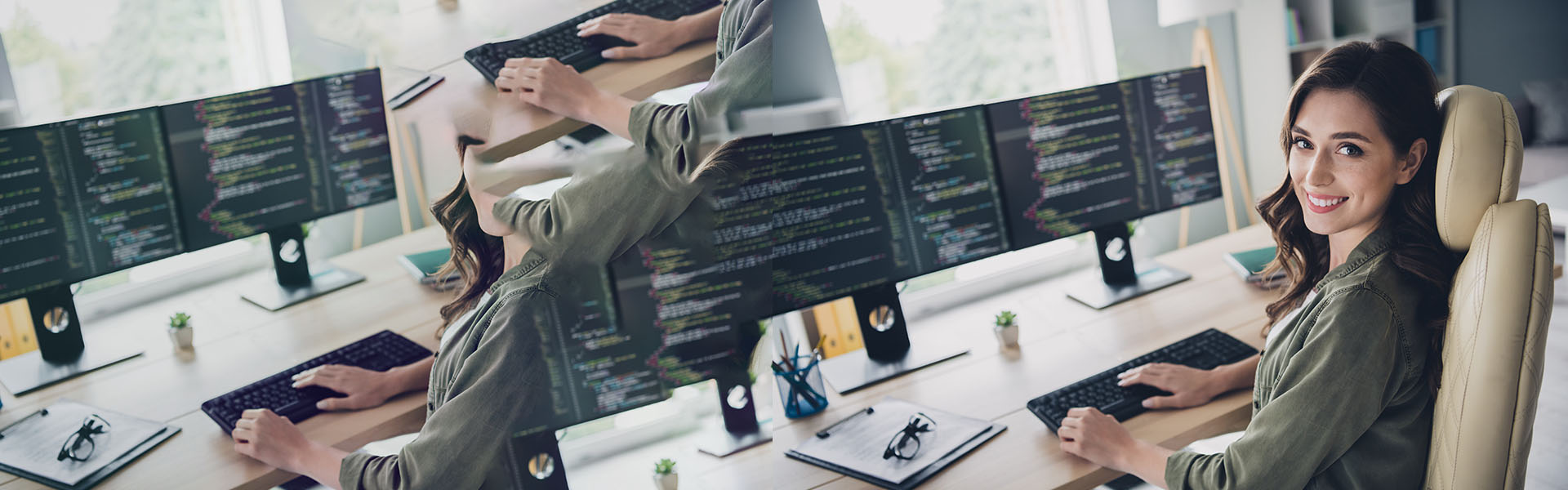 Frau an Schreibtisch vor Bildschirmen mit Code