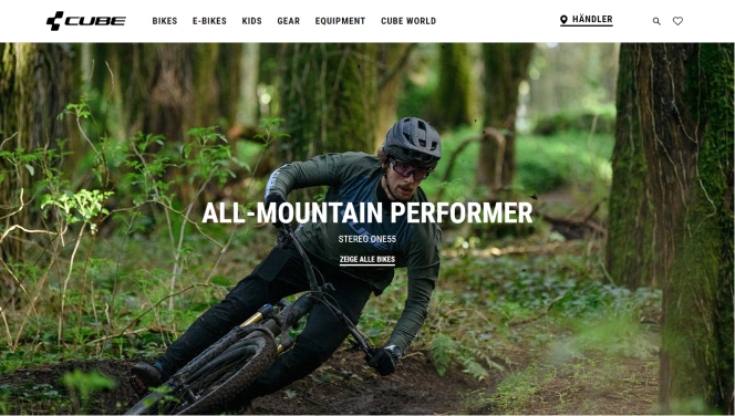  Screenshot der Startseite der Cube-Bikes-Website, zeigt einen Mountainbiker, der durch einen Wald fährt, mit dem Titel 'All-Mountain Performer' und einem CTA-Button zur Anzeige der Bikes. 