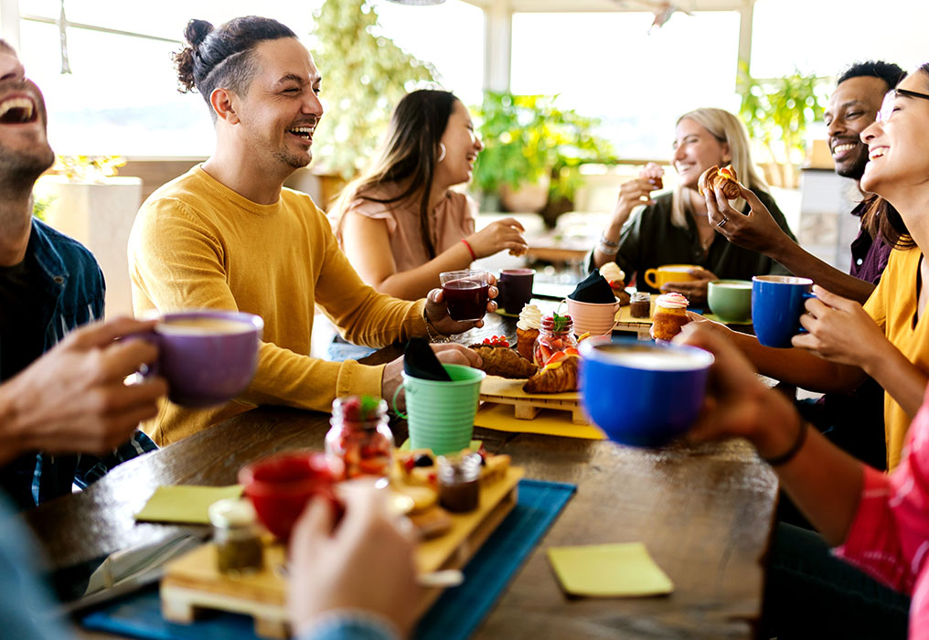 Several employees sit together at the breakfast table and chat
